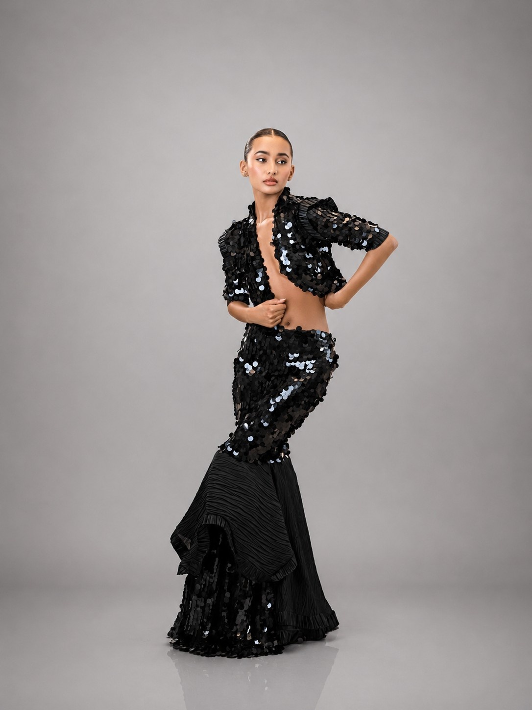 Model in Midnight Muse with one hand at her waist in a studio portrait